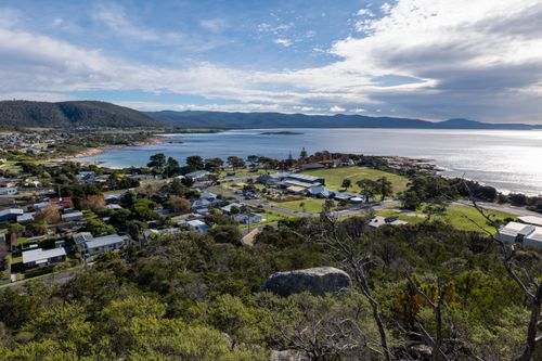 Free Aerial view of a peaceful coastal town with lush greenery and expansive ocean vistas. Stock Photo