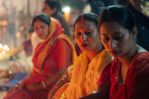 Free Women engaged in a vibrant Indian festival, wearing traditional attire and performing rituals. Stock Photo