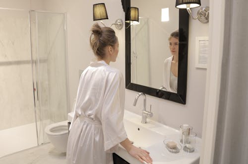 Woman In White Robe Looking At The Mirror