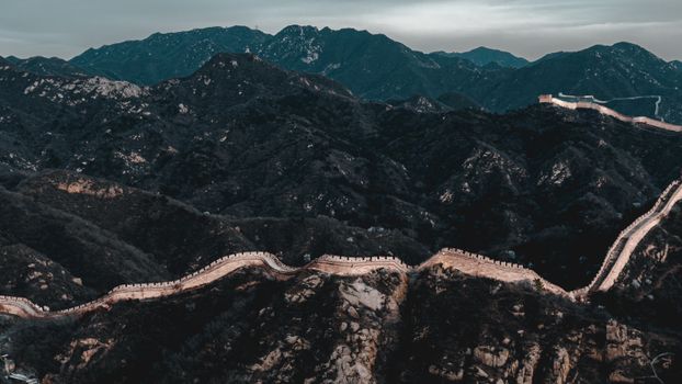 Aerial view of the majestic Great Wall of China winding through rugged mountains.