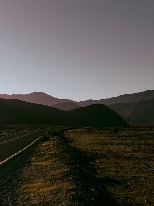 Free Peaceful road amidst La Serena mountains during twilight, capturing serene natural beauty. Stock Photo
