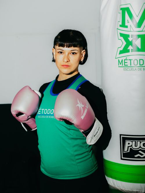 Free Portrait of a female boxer in pink gloves training at a gym in Buenos Aires. Stock Photo