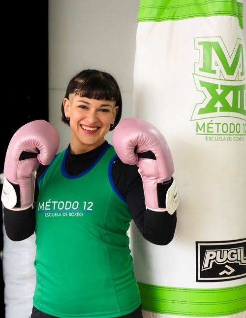 Free Smiling female boxer with pink gloves at Método 12 Boxing Academy in Buenos Aires. Stock Photo