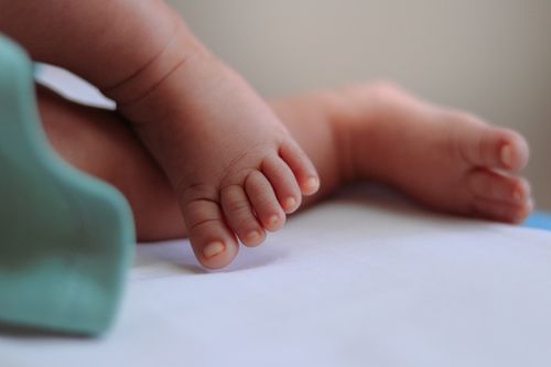 Free Adorable close-up of baby feet on a soft white surface, showcasing warmth and innocence. Stock Photo