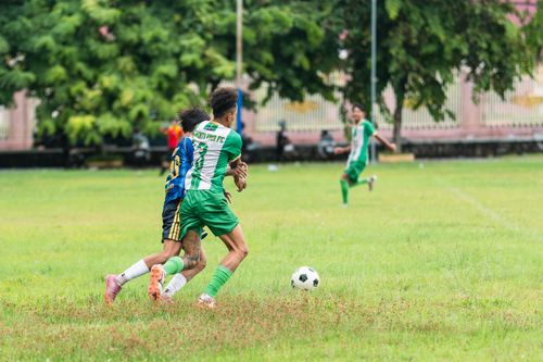 Free Players in a competitive soccer match showing skill and agility on a vibrant green field. Stock Photo