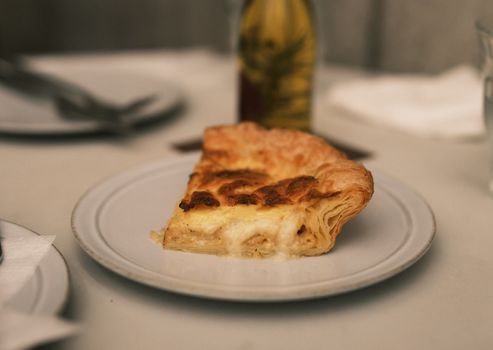 Close-up of a quiche slice served on a white plate, ideal for food visuals.
