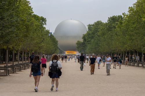 Free People walking towards the iconic hot air balloon feature in Paris, France. Stock Photo