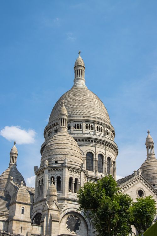 Free Iconic Sacre Coeur Basilica in Paris captured against a bright blue sky on a sunny day. Stock Photo