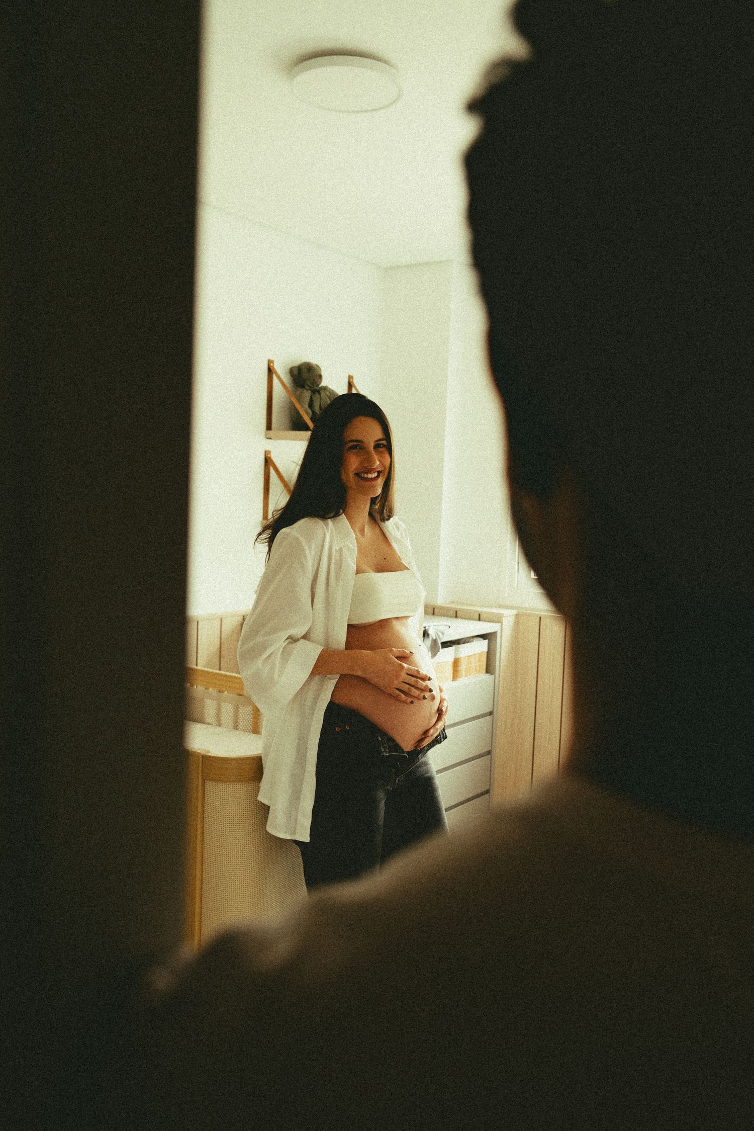 Future maman souriante préparant sereinement la chambre de son bébé