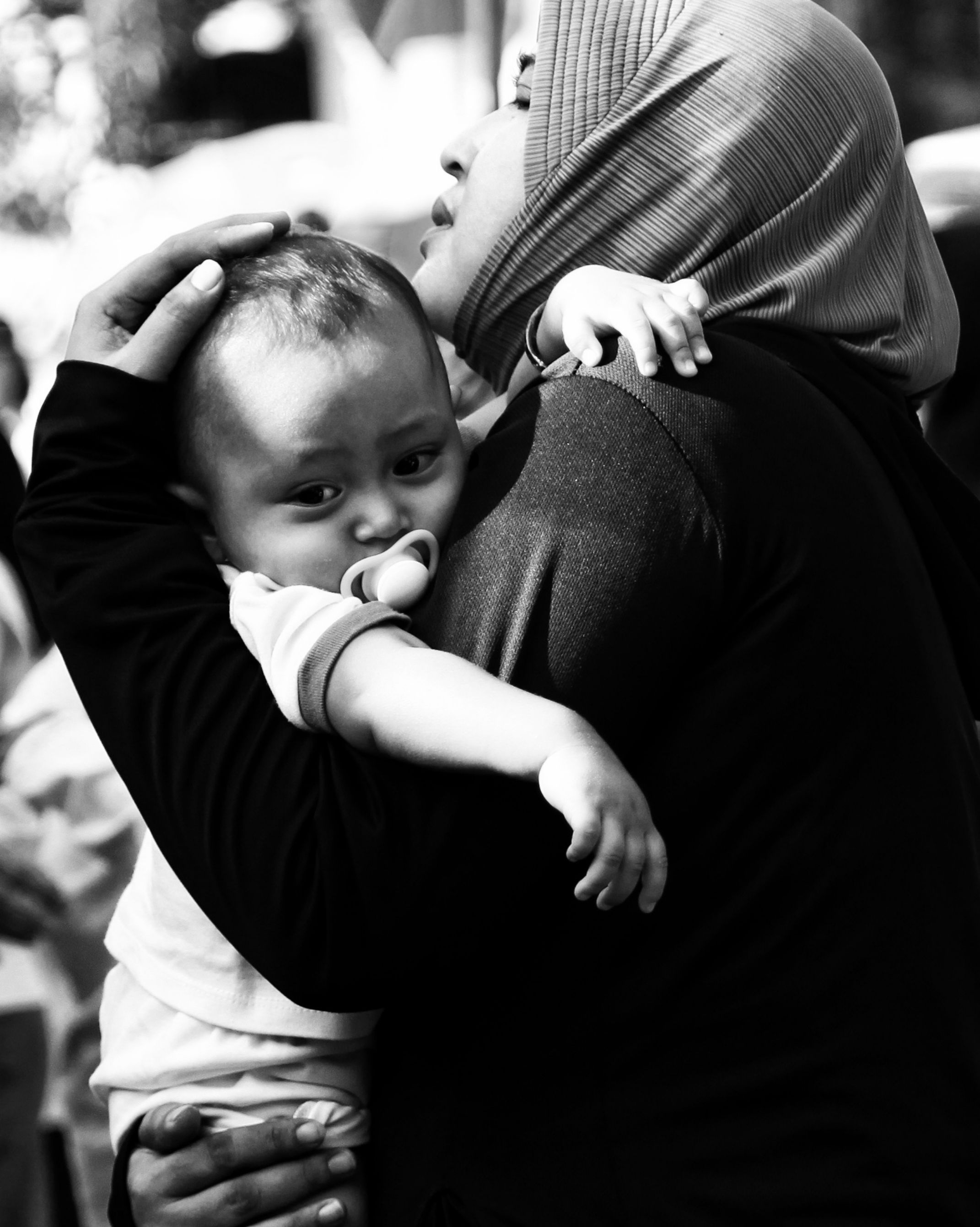 A tender black and white moment of a mother holding her baby in Semarang, Indonesia.