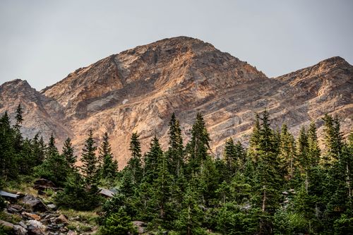 Free Explore the breathtaking mountain landscape featuring rugged peaks and lush evergreen forests. Stock Photo