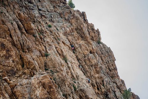 Free Adventurous rock climbers scaling a steep mountain cliff, showcasing courage and outdoor exploration. Stock Photo