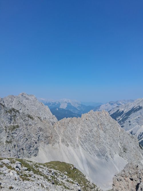 Free Panoramic view of majestic rocky mountains under a bright blue sky, perfect for nature lovers. Stock Photo