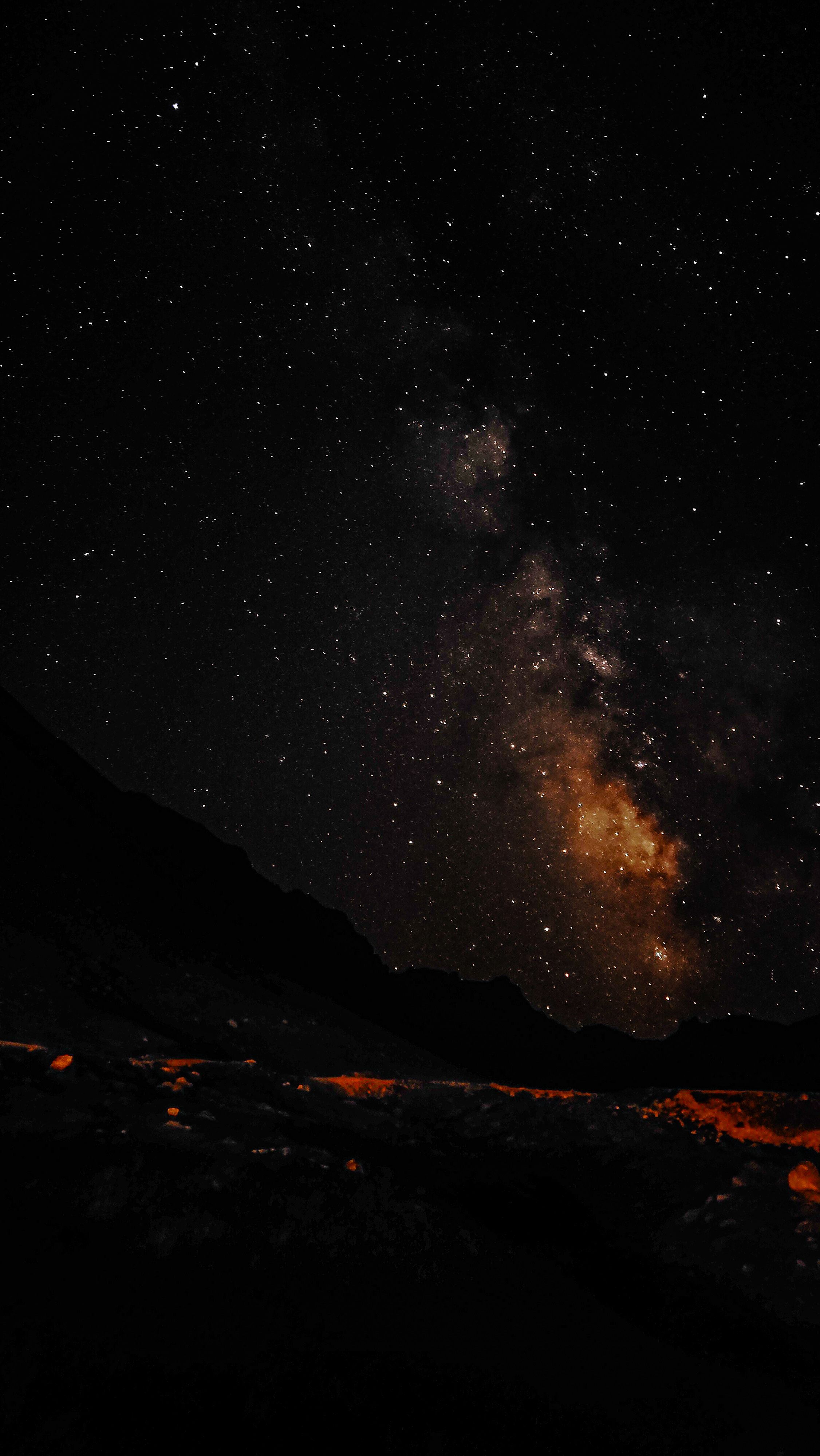 Captivating view of the Milky Way galaxy illuminating the night sky above a silhouette landscape.