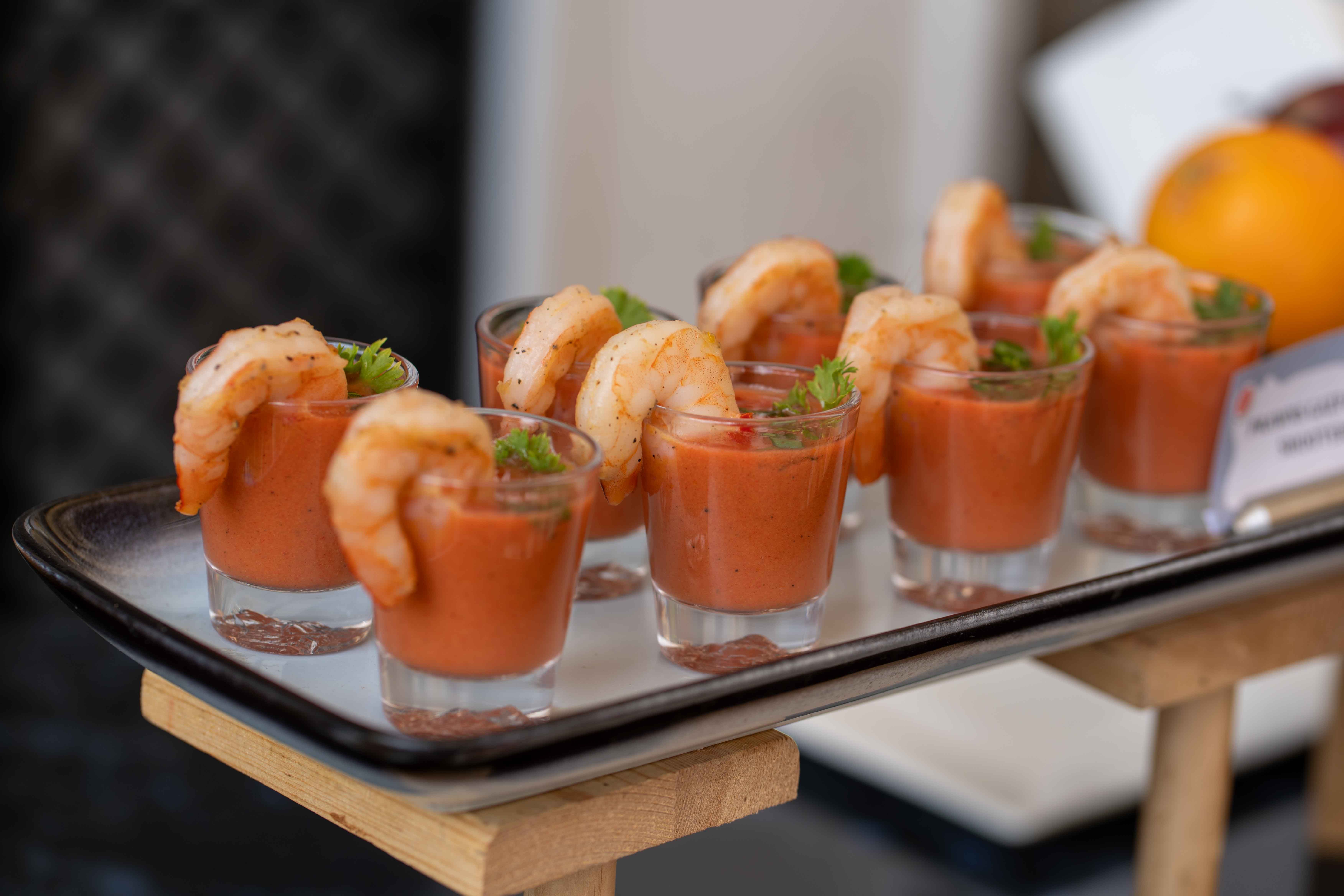 Elegant shrimp cocktails presented in shot glasses with parsley garnish, perfect for catering and event photography.
