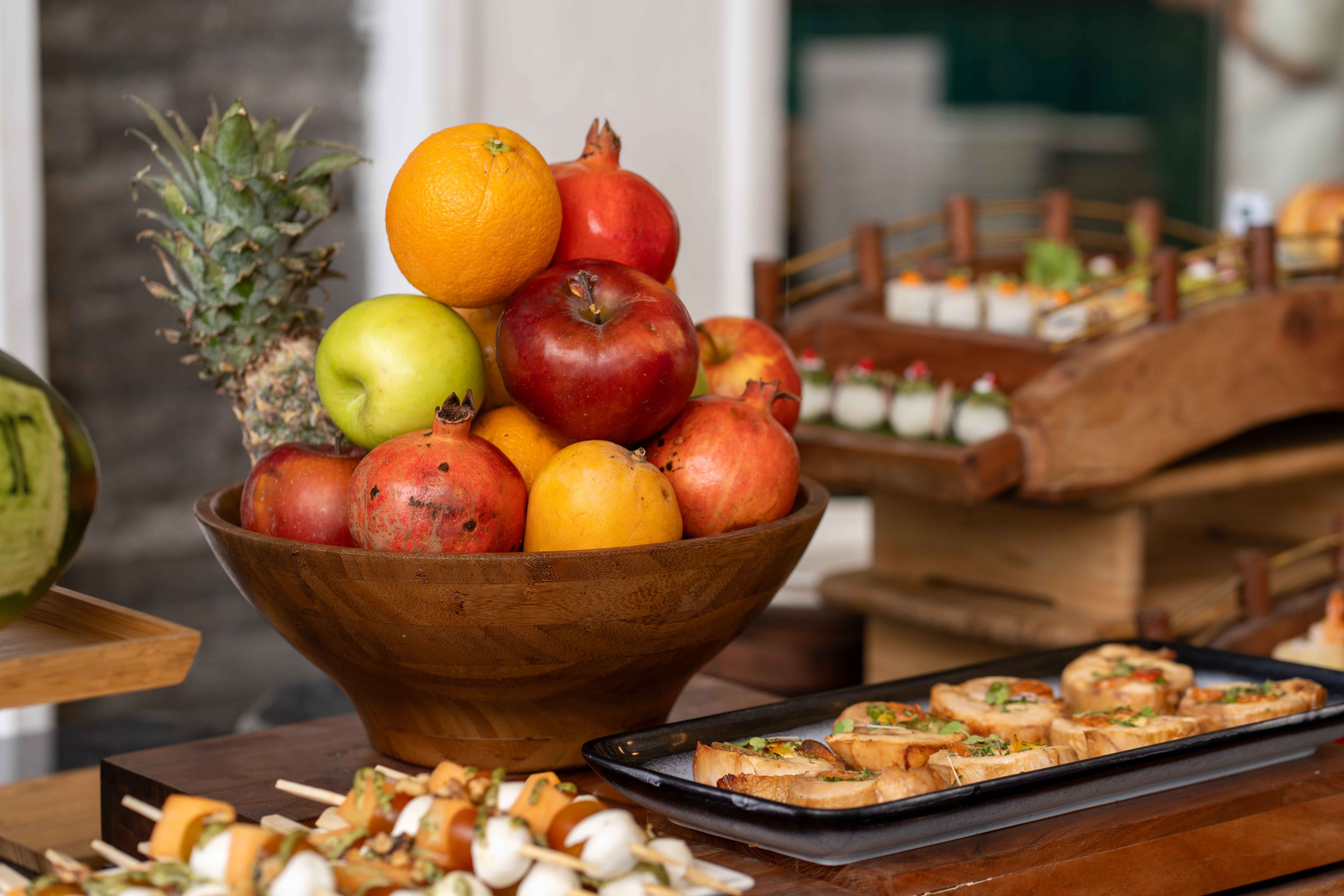 A vibrant display of fresh fruits and appetizers at a buffet, showcasing culinary art and freshness.