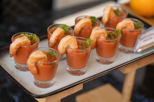 Elegant shrimp cocktail shots served in glass cups with garnish, ideal for appetizers.