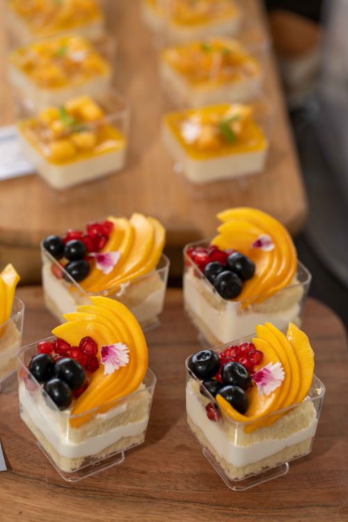 Free Mini cheesecake desserts beautifully adorned with fresh mango, blueberries, and pomegranate. Stock Photo