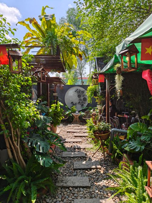 Free A tranquil garden café surrounded by lush greenery in Ho Chi Minh City, perfect for relaxation. Stock Photo