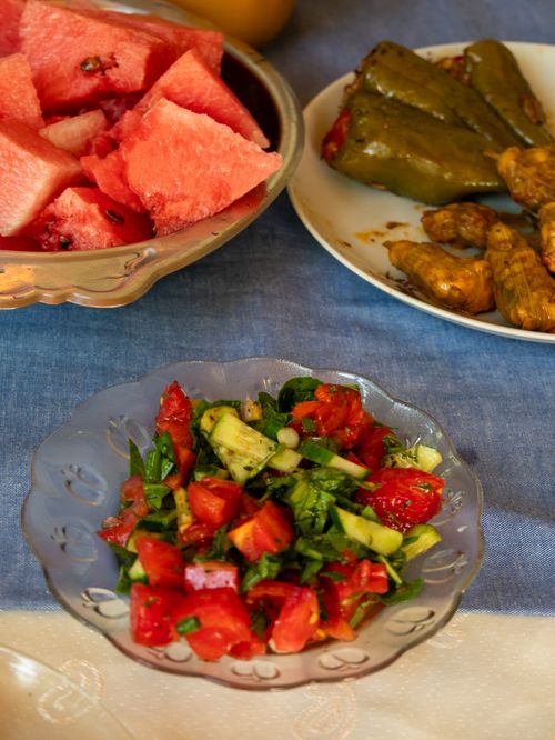Free A colorful Mediterranean meal featuring fresh salads and watermelon on a blue tablecloth. Stock Photo