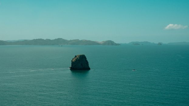 A tranquil scene of the iconic sea rock at Hahei, New Zealand, surrounded by the vast blue ocean.