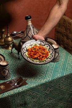 Authentic Moroccan dish served on a decorative plate with traditional tagine set.
