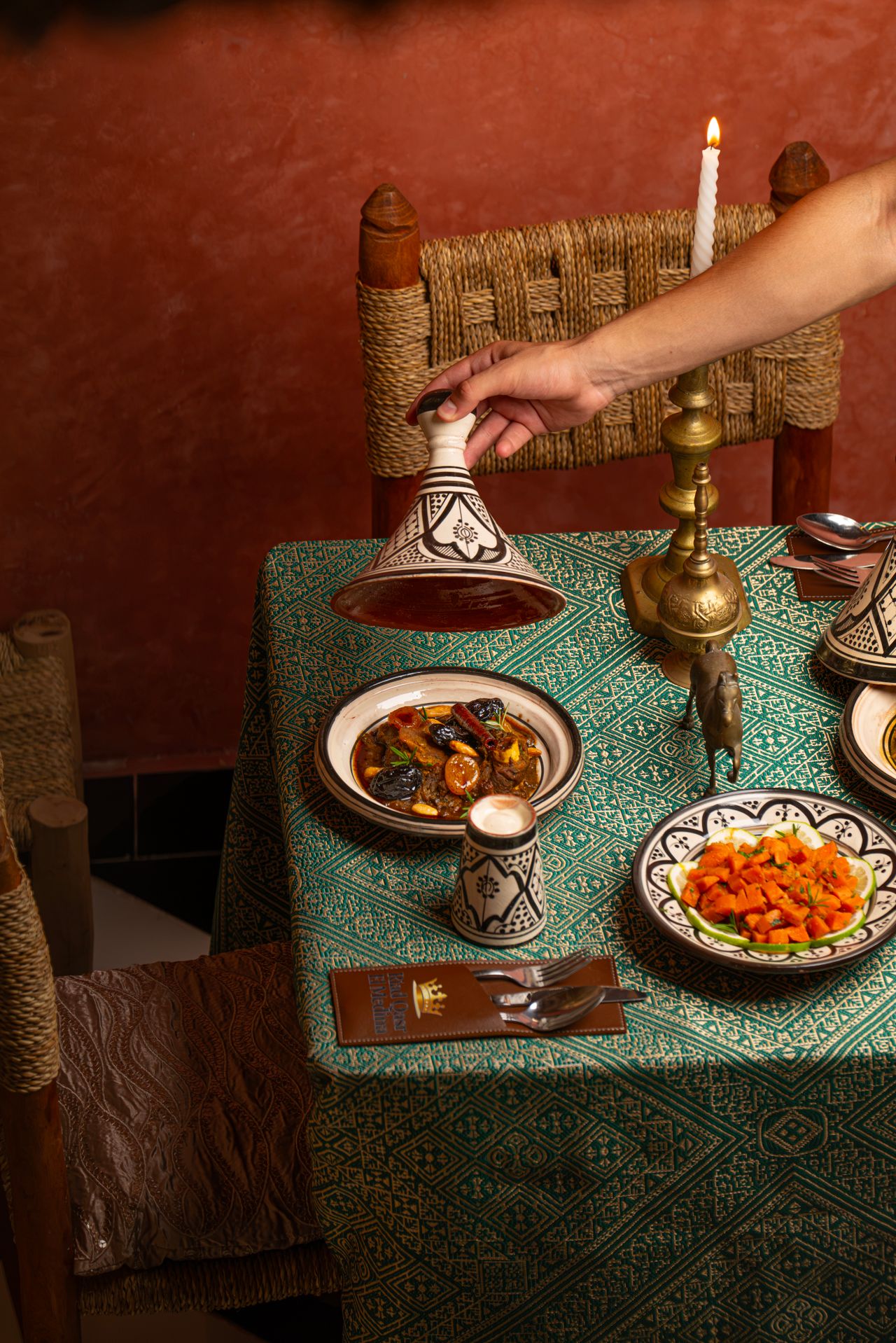 Table marocaine avec tajine et bougie, ambiance chaleureuse