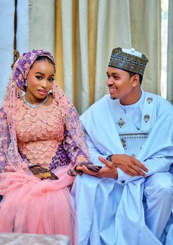 A couple in traditional Nigerian attire celebrating their wedding.