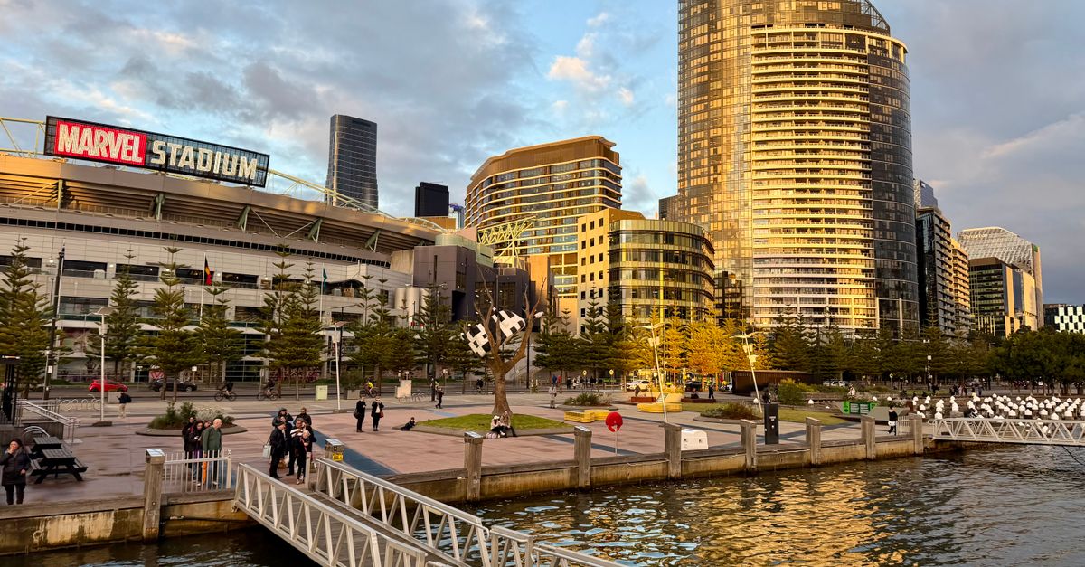 Captivating view of Marvel Stadium and Docklands, Melbourne at sunset. Lively waterfront scene.