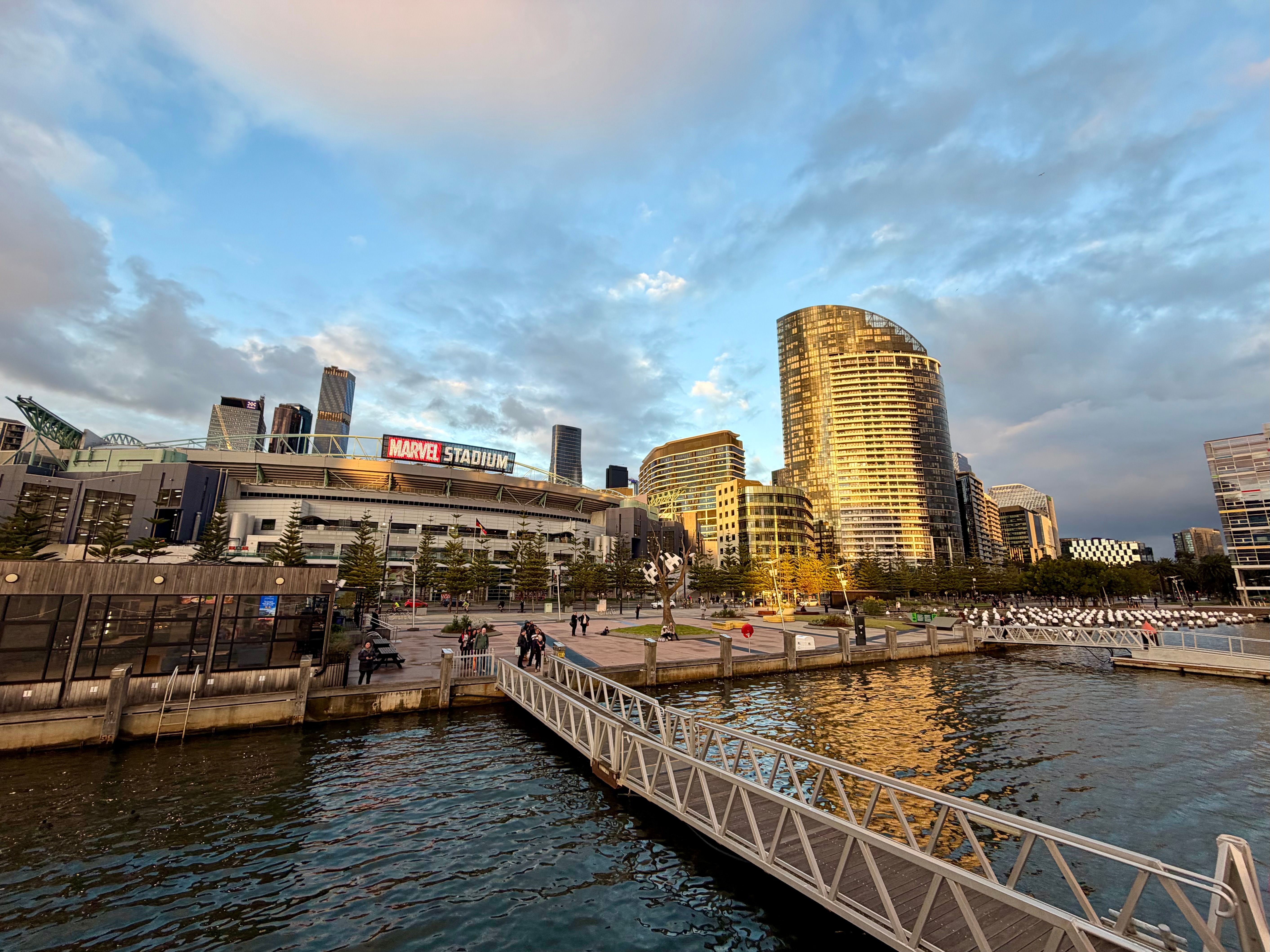 Beautiful Docklands cityscape with Marvel Stadium at sunset reflecting on the water.