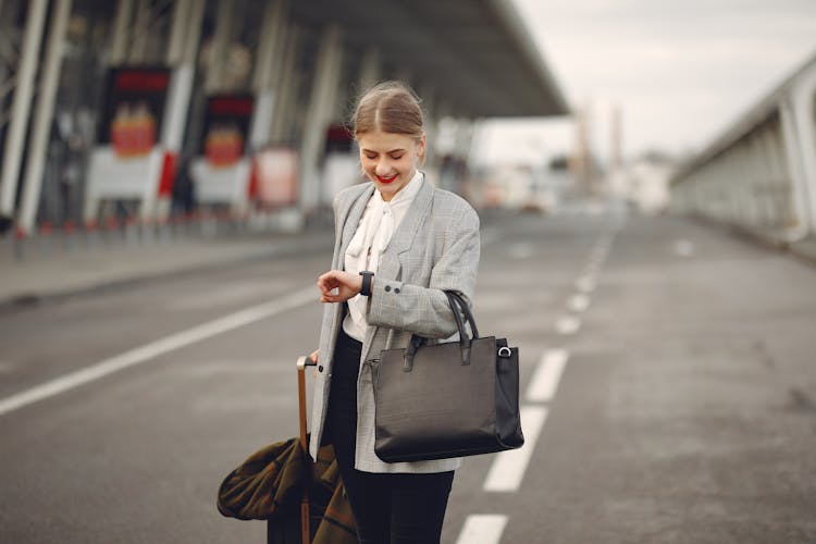 Positive Young Businesswoman With Suitcase Hurrying On Flight On Urban Background