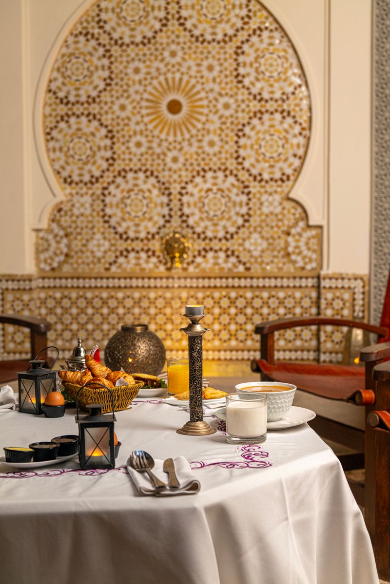 Breakfast laid beneath a carved zellige fountain wall