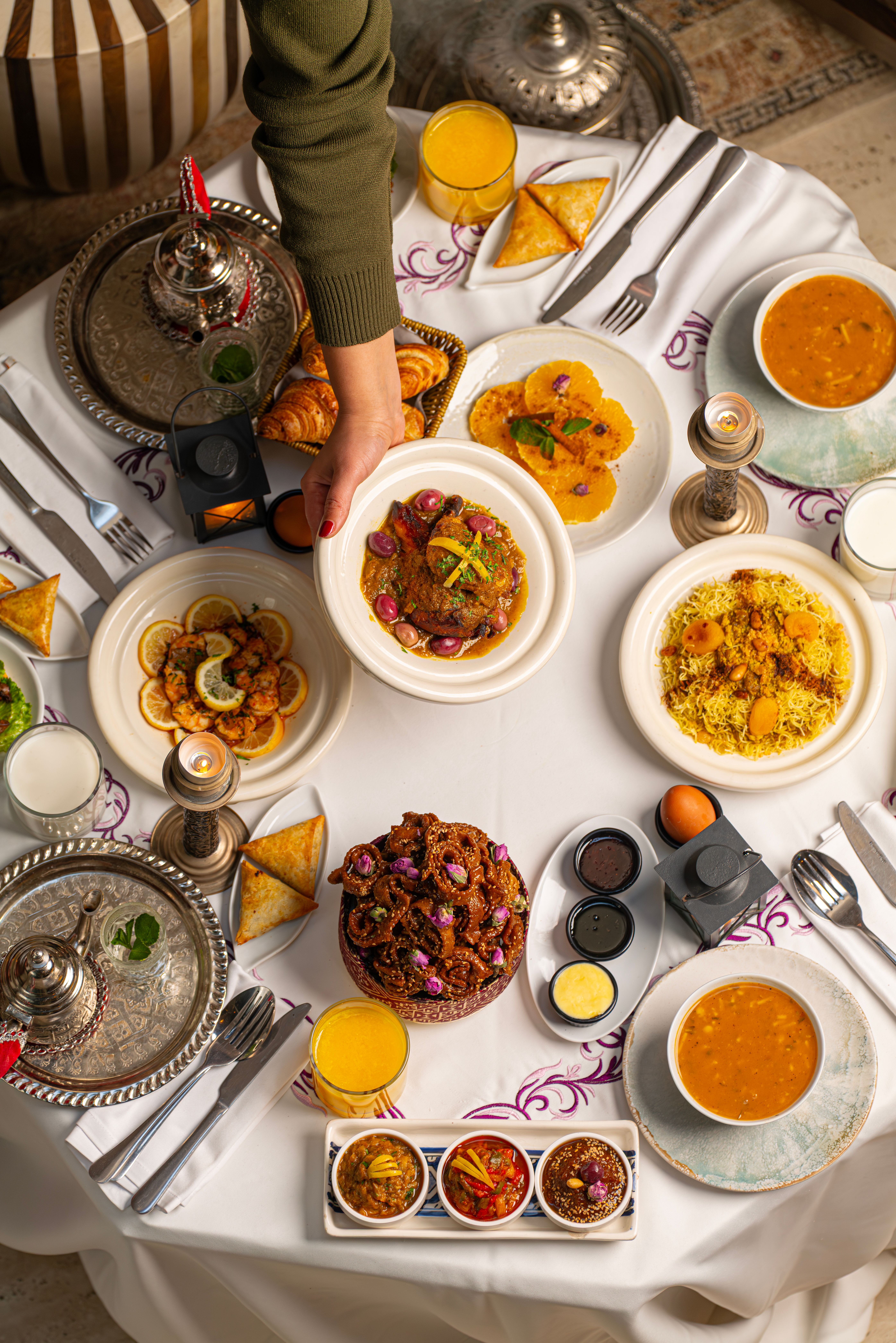 Overhead view of colorful Moroccan dishes beautifully arranged on a dining table.