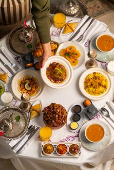 Overhead view of colorful Moroccan dishes beautifully arranged on a dining table.
