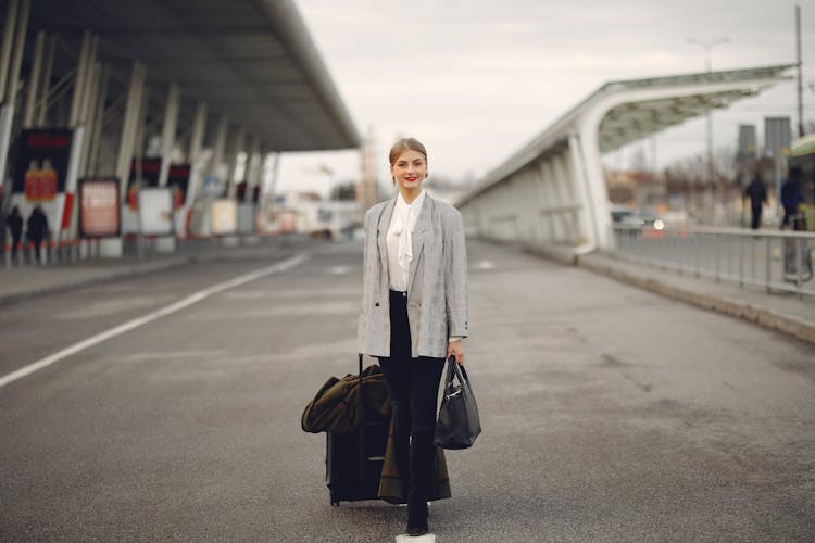 Happy Female Traveler Walking On Airport Street With Luggage