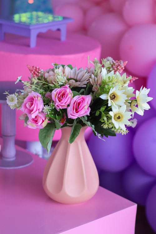 Free Colorful bouquet of flowers in a pink vase against a festive backdrop. Stock Photo