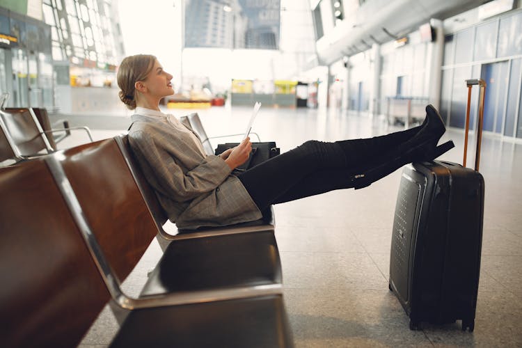 Woman Sitting On A Chair Inside An Airport