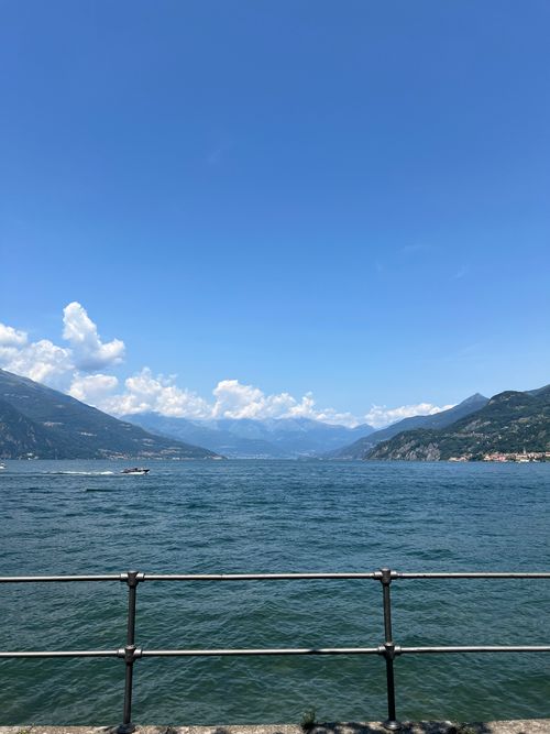 Free A picturesque view of Lake Como with surrounding mountains under a clear blue sky. Stock Photo
