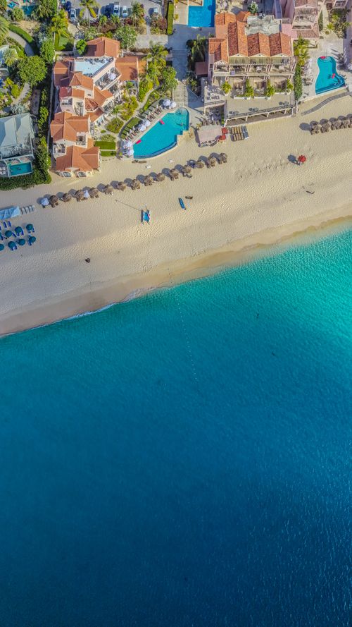 Free Stunning aerial view of a beachfront resort in Anguilla with azure waters and sandy shore. Stock Photo