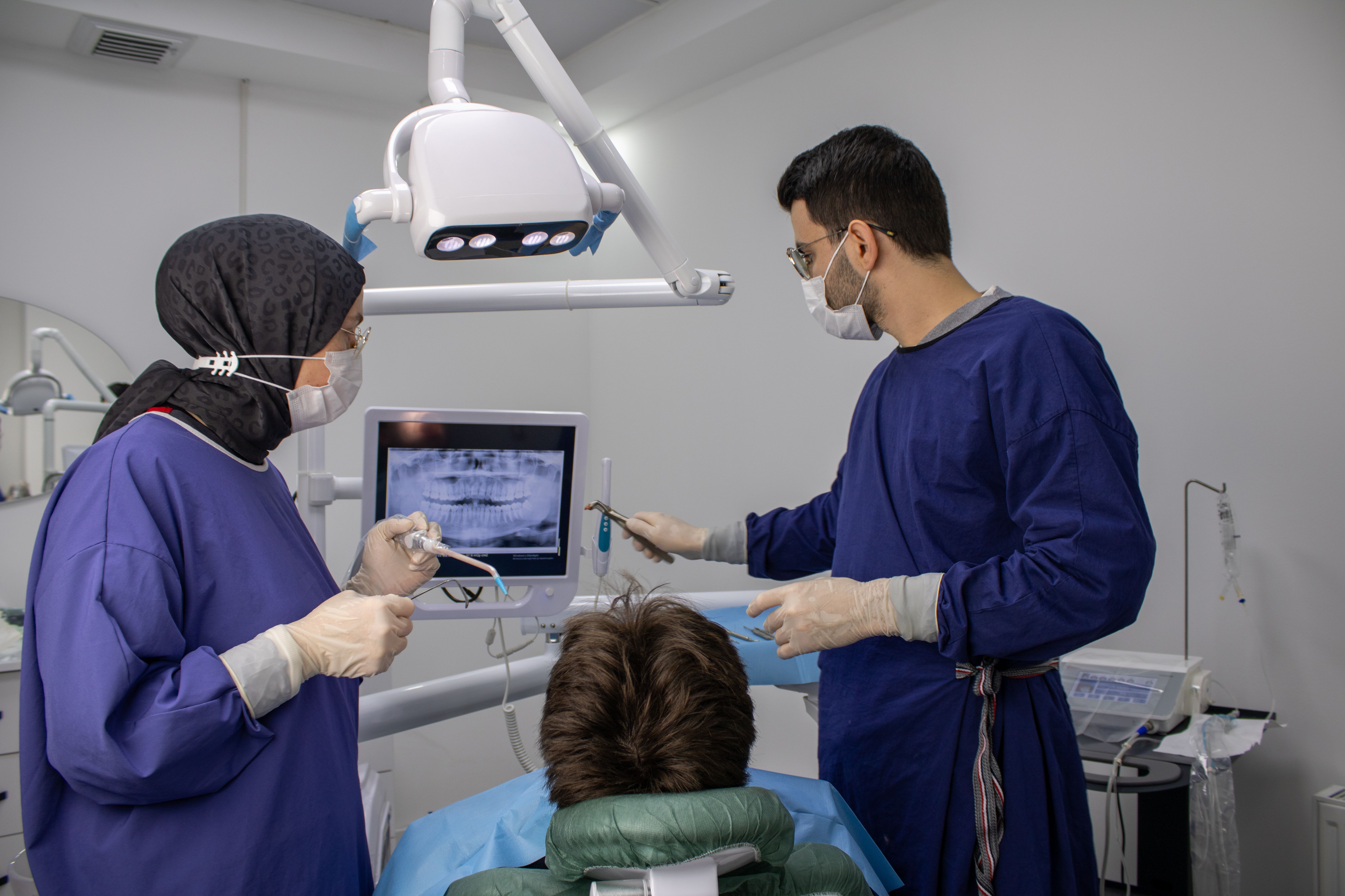 Dentists and patient during a dental checkup in a modern clinic setting, focusing on oral hygiene.