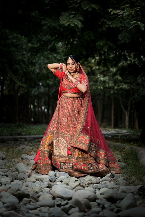 Free Beautiful Indian bride in a traditional lehenga posing outdoors in Lucknow, India. Stock Photo