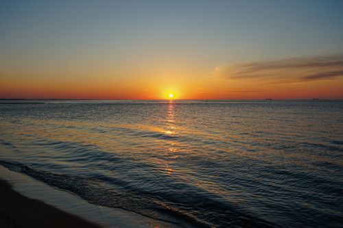 Free A serene ocean sunset with warm hues reflecting on calm waters, capturing the essence of nature's beauty. Stock Photo