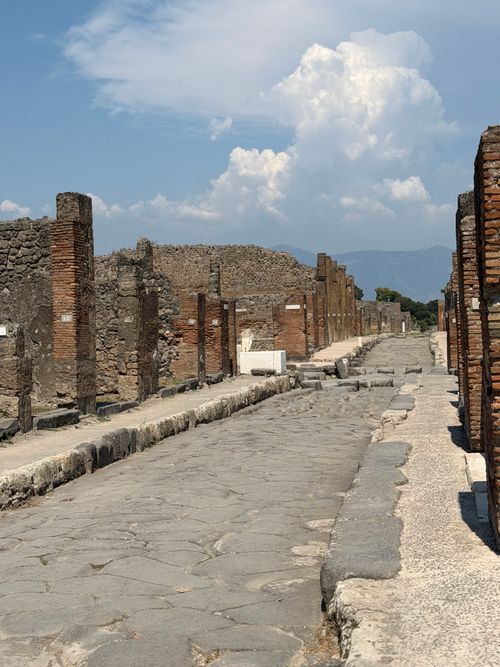Free Explore the historic ruins of Pompeii with this striking image of an ancient Roman road. Stock Photo