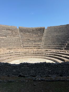 Explore the timeless beauty of the ancient amphitheater in Pompeii, Italy under a clear blue sky.