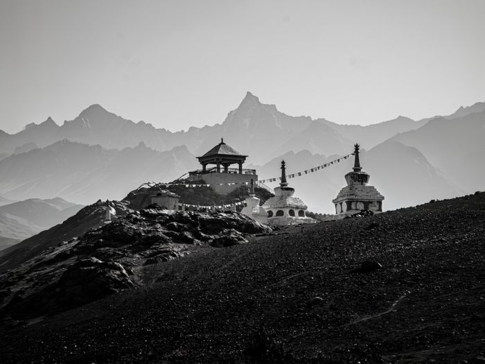 Dramatic black and white scene of Buddhist stupas with mountain backdrop in Spiti Valley, , by Mangalam Bhargava on Pexels