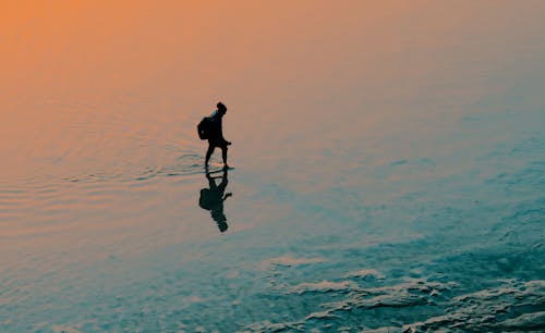 Silueta, De, Persona Estar De Pie, En, Cuerpo De Agua