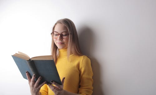 Woman In Yellow Sweater Holding A Book