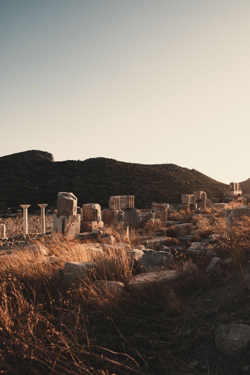 Free Explore ancient ruins amidst a serene sunrise, with historic stone structures and columns in a tranquil landscape. Stock Photo
