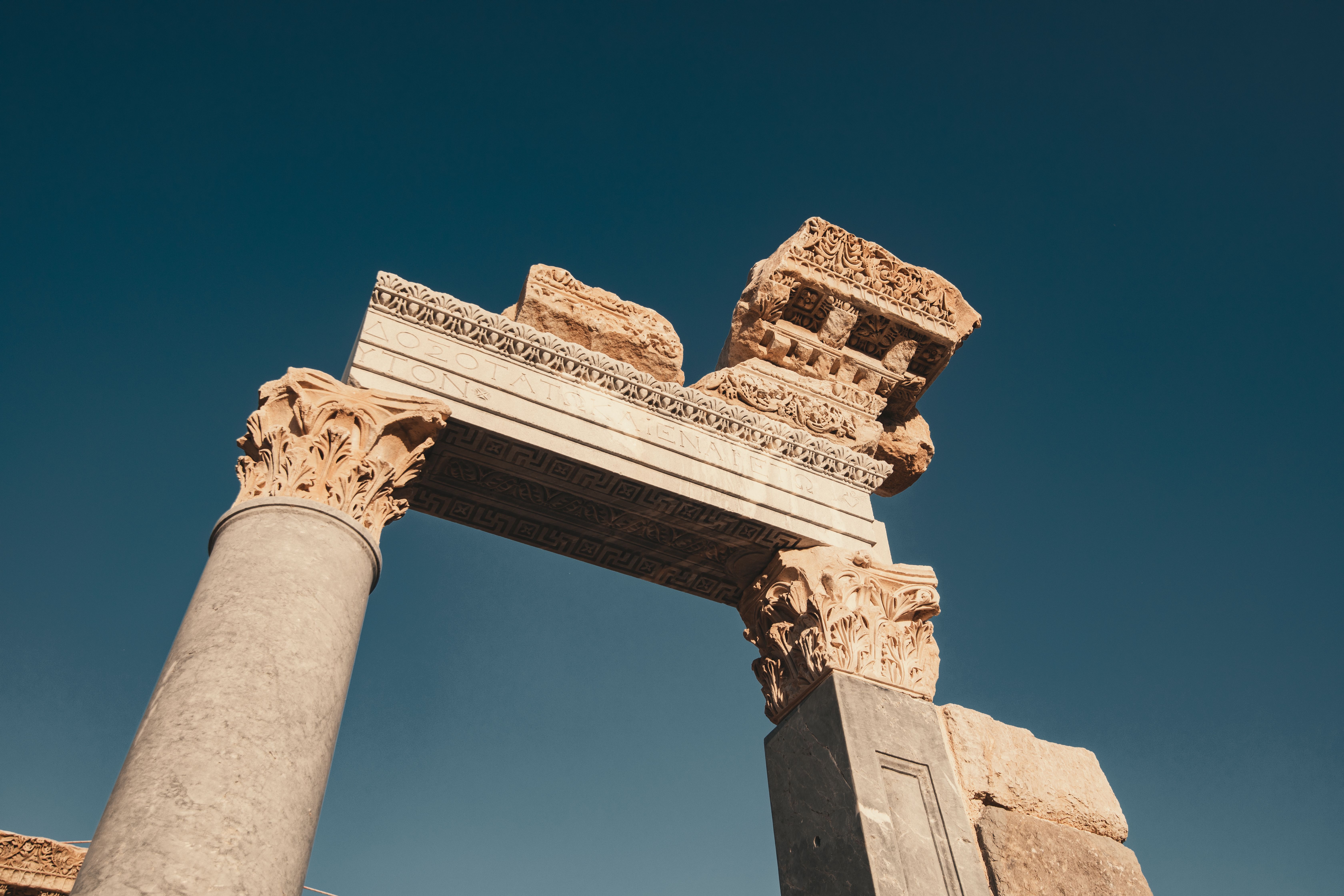 A stunning view of ancient Roman ruins with intricate carvings under a clear blue sky.