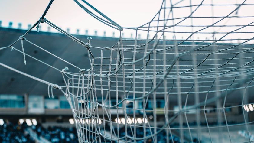 A goal net in close-up with the stadium stands behind — photo by Julio Cardoso on Pexels